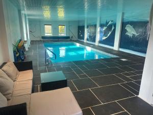 a swimming pool in a room with a couch at Belton House Holiday Home in Wanlockhead