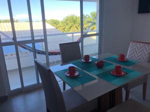 a table with two cups on it with a view of the ocean at TRANQUILA FLATS in Morro de São Paulo