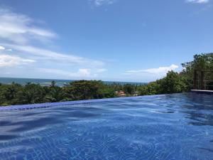 a swimming pool with a view of the ocean at TRANQUILA FLATS in Morro de São Paulo