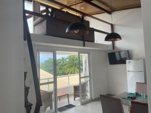 a kitchen with a view of a room with a window at TRANQUILA FLATS in Morro de São Paulo