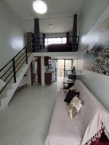 a living room with a couch and a staircase at GUARATUBA LOFTS in Guaratuba