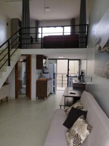 a living room with a couch and a staircase at GUARATUBA LOFTS in Guaratuba