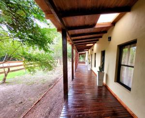 un porche de una casa con terraza de madera en Hostería Jasy en Colonia Carlos Pellegrini