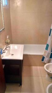 un baño con lavabo y bañera en casa a 1 del mar, en Mar Azul