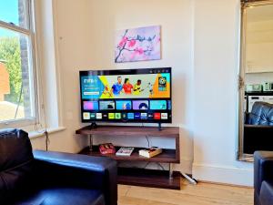uma televisão de ecrã plano numa sala de estar em King's Cross 4 Bedrooms Home with Private Rooftop em Londres