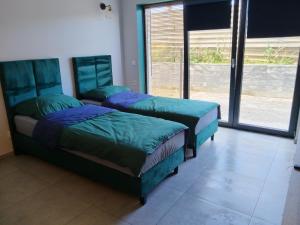 a bedroom with two beds and a large window at Prawnicza50 in Żory