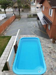 uma piscina azul num parque de estacionamento em GUARATUBA LOFTS em Guaratuba