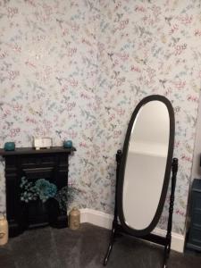 a mirror in a room with floral wallpaper at The Nifty Nook in Campbeltown