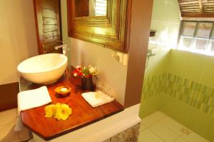 a bathroom with a wooden counter with a sink and a tub at Samaria Lodge in Sainte Marie