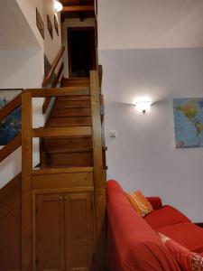 - un salon avec un escalier et un canapé rouge dans l'établissement Casa Bellavista, à Civenna