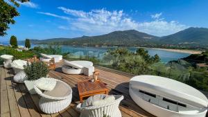 una terraza con sillas blancas y vistas al agua en A'mare Corsica I Seaside Small Resort, en Propriano