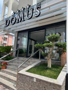 a domus building with stairs in front of it at Domus Hotel & Apartments in Shëngjin