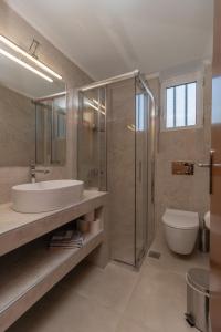 La salle de bains est pourvue d'un lavabo, d'une douche et de toilettes. dans l'établissement Lagouvardos Apartments, à Marathopolis