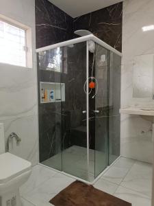um chuveiro com uma porta de vidro na casa de banho em casa ampla com PISCINA e área verde em São José ao lado de Maragogi em São José da Coroa Grande