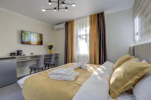 um quarto com uma cama grande e uma mesa em Viva Hotel em Bishkek