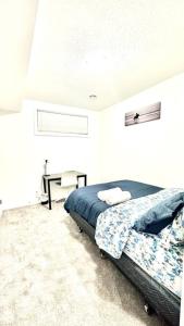 1 dormitorio con 1 cama en una habitación blanca en The Cozy Nest en Calgary
