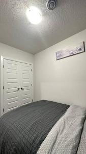 1 dormitorio con cama y techo en The Cozy Nest, en Calgary