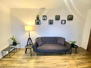 a living room with a blue couch and pictures on the wall at Psí bouda Benecko in Benecko