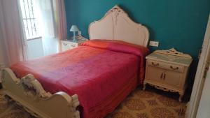 1 dormitorio con 1 cama con manta roja y 2 mesitas de noche en Una casa azul en el sur, en Manzanilla