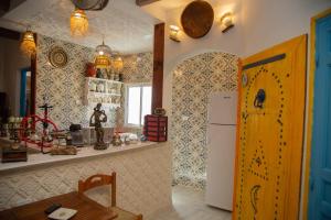 a kitchen with a white refrigerator and a table at Dar Amazigh in Tozeur