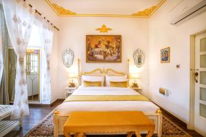 een slaapkamer met een bed en een schilderij aan de muur bij The Royal Hermitage - Best Luxury Boutique Hotel Jaipur in Jaipur