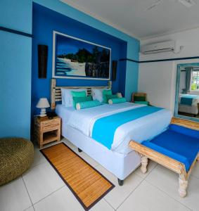 ラ・レユニオンにあるVilla Charme de L'ileの青い壁のベッドルーム1室(大型ベッド1台付)