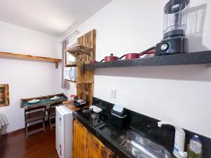 uma cozinha com um fogão e uma bancada em Suíte confortável no Centro de Caratinga em Caratinga