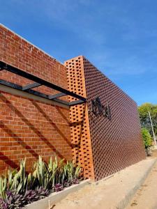 Una pared de ladrillo con un cartel en el costado. en Lyttos Bungalows en Icapuí