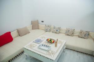 a living room with a white couch with a table at Dar Amazigh in Tozeur