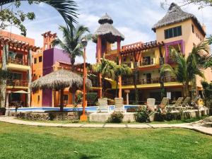 a resort with a swimming pool and palm trees at Villas Dulce Suenos in Rincon de Guayabitos