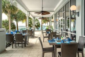 Un restaurante con mesas y sillas y el océano. en Marriott Sanibel Harbour Resort & Spa, en Fort Myers