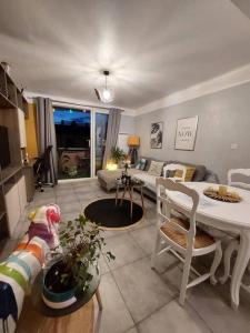uma sala de estar com um sofá e uma mesa em Appartement T3 avec balcon, centre 15’ à pied em Aix-en-Provence