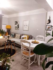 uma sala de estar com uma mesa e um sofá em Appartement T3 avec balcon, centre 15’ à pied em Aix-en-Provence