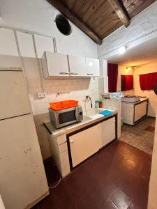 a kitchen with a sink and a microwave at El rancho - Espaciosa Casa para 7 en un Oasis de Tranquilidad in Villa Serrana