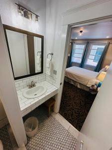 a bathroom with a sink and a bed in a room at The Edgewater in Avalon