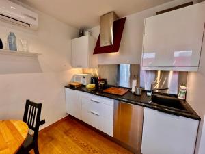 uma cozinha com armários brancos e um balcão preto em FORUM 3 metro fast WiFi 400 Mbs TV HBO Disney+ em Varsóvia