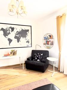 un soggiorno con divano nero e una mappa del mondo sul muro di Gemelli-San Pietro-Trastevere-casa con posto auto a Roma