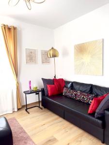 a black couch with red pillows in a living room at Gemelli-San Pietro-Trastevere-casa con posto auto in Rome