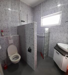 a bathroom with a white toilet and a sink at Sa-Ra's vakantiehuis in Paramaribo