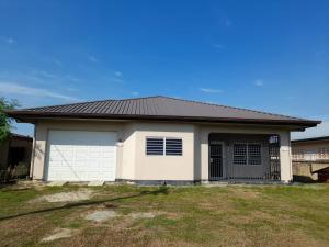 ein Haus mit einem schwarzen Dach und einer Garage in der Unterkunft Sa-Ra's vakantiehuis in Paramaribo