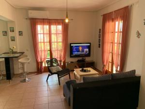 a living room with a couch and a tv at La Bandolaise à Perdika in Perdika