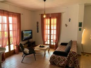 a living room with a couch and a tv at La Bandolaise à Perdika in Perdika