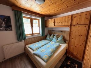 ein Schlafzimmer mit einem Bett in einem Holzzimmer in der Unterkunft Apartment Familie Thomas und Angelika Melmer in Sankt Leonhard im Pitztal