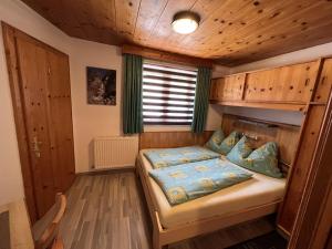 ein Schlafzimmer mit einem Bett in einem Holzzimmer in der Unterkunft Apartment Familie Thomas und Angelika Melmer in Sankt Leonhard im Pitztal