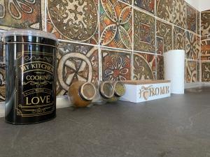 a counter with a can and a wall with tiles at La Bandolaise à Perdika in Perdika