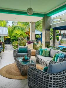 a patio with couches and chairs and a table at Villa Charme de L'ile in La Réunion