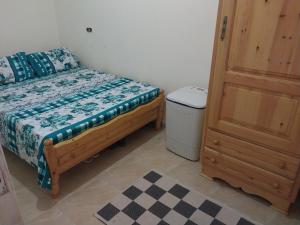a small bedroom with a bed and a trash can at Beachside Chalet ,Sidi kerir in Abû Zeira
