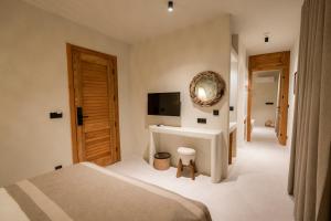 een slaapkamer met een bed, een wastafel en een televisie bij Bitez Corner Boutique Hotel in Bitez