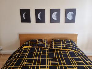 1 dormitorio con 1 cama con 4 fotos de la luna en Easy living near Angel and City University, en Londres