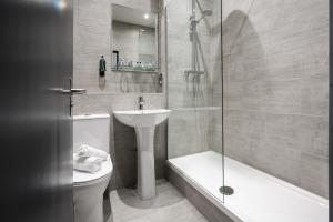 a bathroom with a sink and a toilet and a shower at The Coachman Hotel in Kilsyth